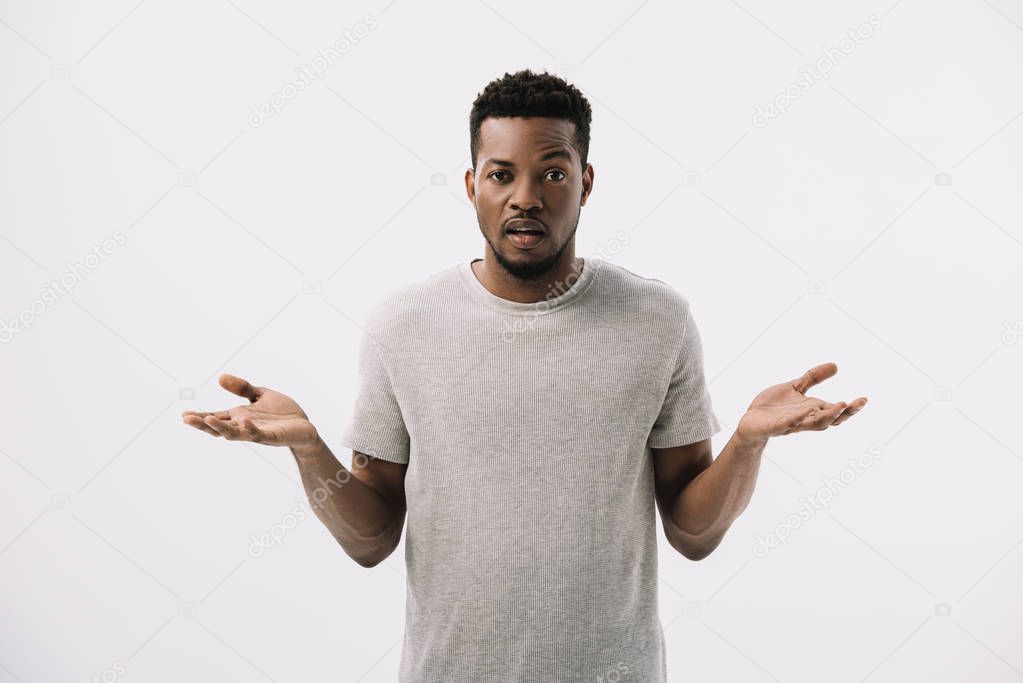 confused african american man showing shrug gesture isolated on grey 