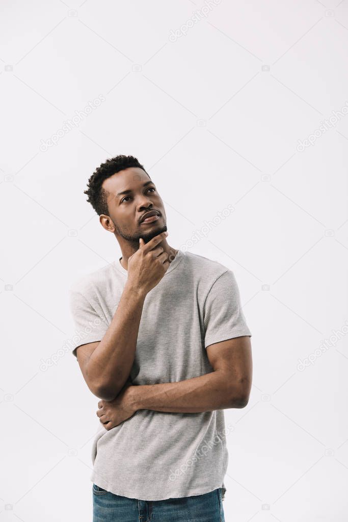 pensive african american man standing and touching face isolated on white 