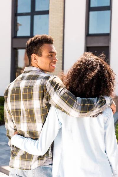 Africano Americano Hombre Abrazando Esposa Mirando Cámara Mientras Caminando Casa — Foto de Stock