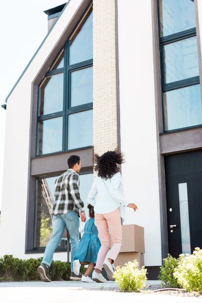 Vista Trasera Pareja Afroamericana Con Niño Corriendo Casa Nueva —  Fotos de Stock