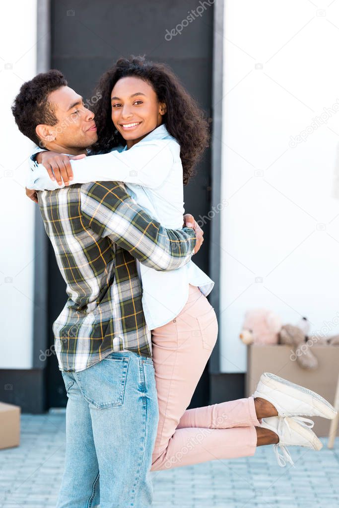 african american husband holding wife in hand while woman looking at camera
