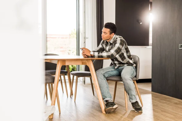 Masa Nın Önünde Oturan Akıllı Telefon Kullanarak Yakışıklı Afro Amerikan — Stok fotoğraf
