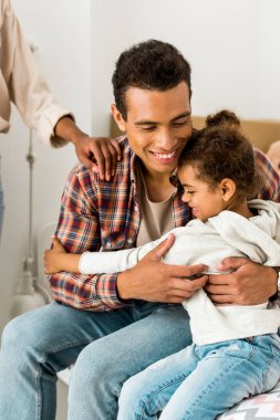 cropped view of woman touching sholder of african american man while dad hugging daughter  clipart