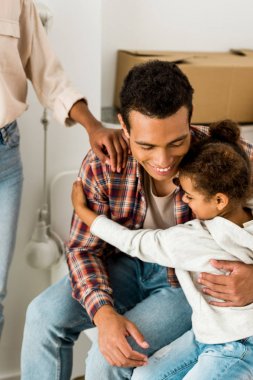 cropped view of woman touching sholder of african american husband while man hugging daughter  clipart