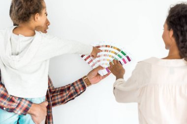 beyaz izole renkli paletkendi duvar için renk seçmek için çalışan afrikalı amerikalı aile