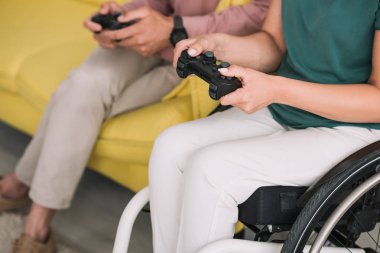 Kiev, Ukrayna - 10 Temmuz 2019: Evde erkek arkadaşı ile video oyunu oynayan engelli kadının kısmi görünümü.