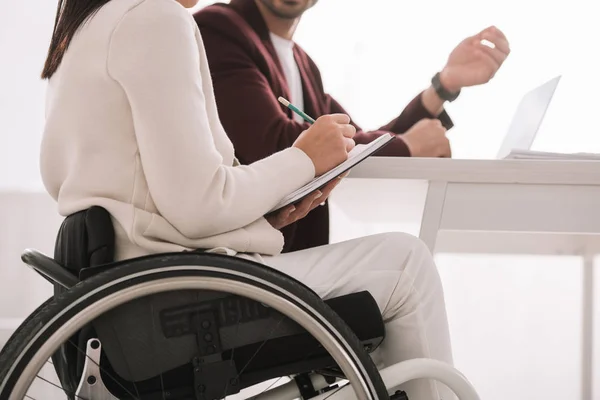 Cropped View Disabled Businesswoman Writing Notebook While Sitting Business Partner — Stock Photo, Image