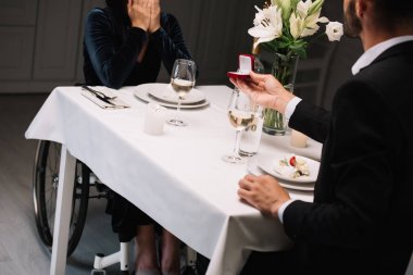 romantik akşam yemeği sırasında engelli kız arkadaşı için düğün teklifi yapan adam kırpılmış görünümü