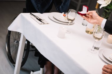 romantik akşam yemeği sırasında engelli kız arkadaşı için düğün teklifi yapan adam kırpılmış görünümü