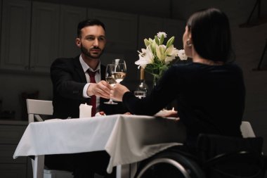 romantik akşam yemeği sırasında yakışıklı erkek arkadaşı ile kırmızı şarap bardakları clinking engelli genç kadın geri görünümü