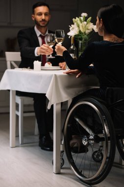 romantik akşam yemeği sırasında erkek arkadaşı ile beyaz şarap bardak clinking engelli genç kadın geri görünümü
