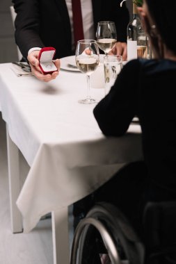 romantik akşam yemeği yerken engelli genç kadına evlilik teklifi yapan erkek arkadaşın kısmi görünümü