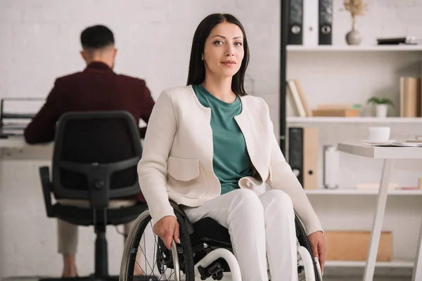 Smiling Disabled Businesswoman Looking Camera While Sitting Wheelchair Colleague Working — Stock Photo, Image