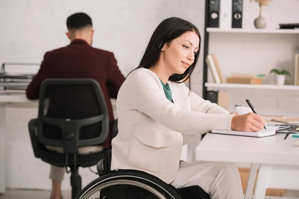 Alegre Mujer Negocios Discapacitada Escribiendo Cuaderno Mientras Está Sentada Silla —  Fotos de Stock