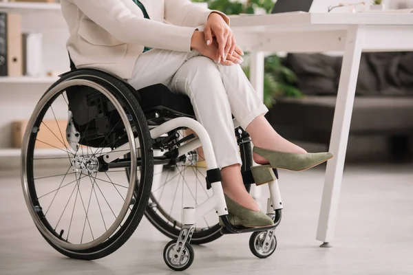 十字架の足で車椅子に座っている障害のあるビジネスウーマンのトリミングされたビュー — ストック写真