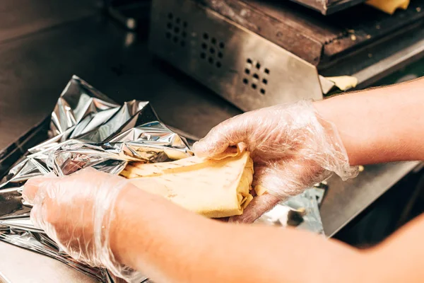 ドナーケバブを準備しながら アルミニウム箔を使用して手袋の調理の部分的なビュー — ストック写真