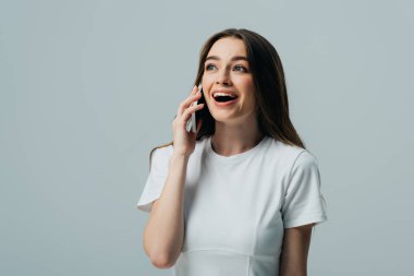 gri izole akıllı telefon konuşurken beyaz t-shirt heyecanlı sürpriz güzel kız