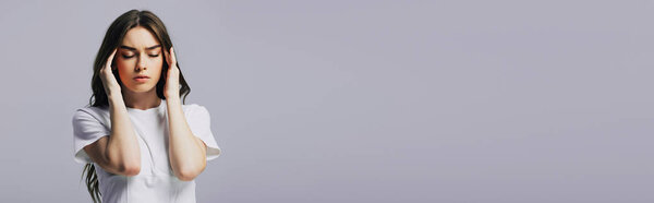 красивая девушка в белой футболке страдает от головной боли, изолированной на сером, панорамный снимок
