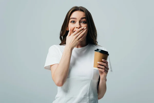 happy surprised beautiful girl in white t-shirt with paper cup isolated on grey