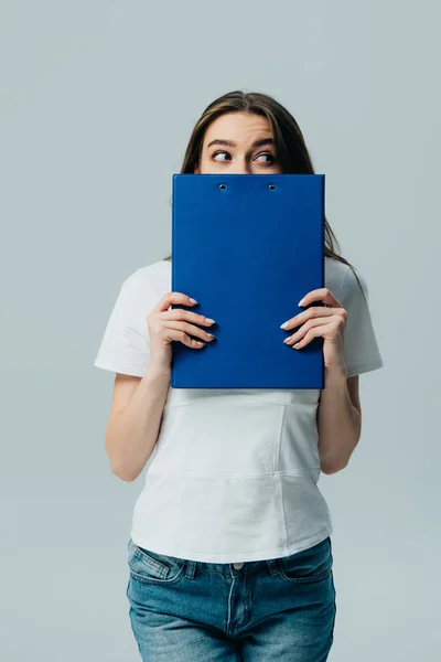 Hermosa Chica Camiseta Blanca Sosteniendo Portapapeles Azul Frente Cara Mirando — Foto de Stock