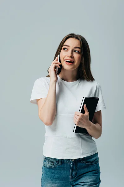 Menina Bonita Feliz Shirt Branca Falando Smartphone Segurando Notebook Isolado — Fotografia de Stock