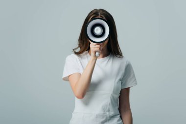 gri izole yüz önünde hoparlör tutan genç güzel kadın