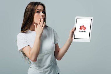Kiev, Ukrayna - 6 Haziran 2019: Huawei simgesi gri izole ile dijital tablet gösteren beyaz t-shirt şok güzel kız