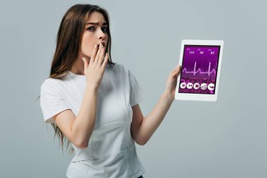 gri izole uygulaması ile dijital tablet gösteren beyaz t-shirt şok güzel kız