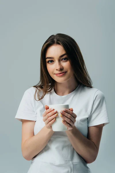 Bonita Chica Sonriente Camiseta Blanca Sosteniendo Taza Blanca Aislada Gris — Foto de Stock