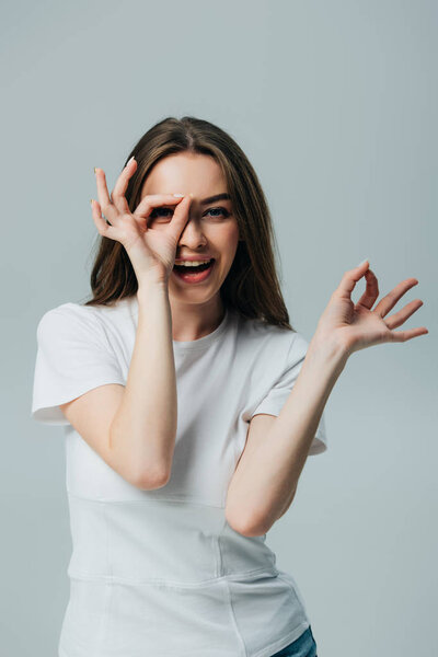 beautiful happy girl showing okay signs isolated on grey