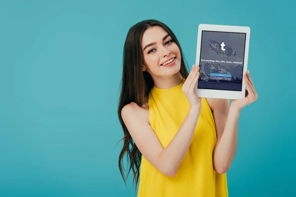 乌克兰 2019年6月6日 快乐美丽的女孩在黄色礼服显示数字平板电脑与Tumblr应用程序隔离在绿松石 — 图库照片