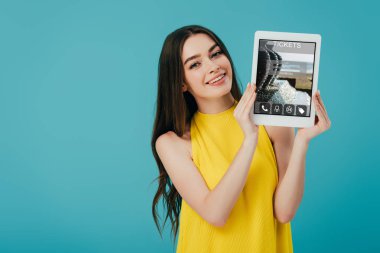 turkuaz izole bilet uygulaması ile dijital tablet gösteren sarı elbiseli güzel kız