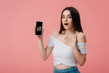 Kiev, Ukrayna - 6 Haziran 2019: pembe izole deezer uygulaması ile akıllı telefon tutan güzel şok kız