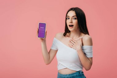 Kiev, Ukrayna - 6 Haziran 2019: pembe izole instagram uygulaması ile akıllı telefon tutan güzel şok kız