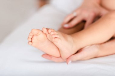 Küçük kızın bacaklarına dokunan kadının kırpılmış görünümü
