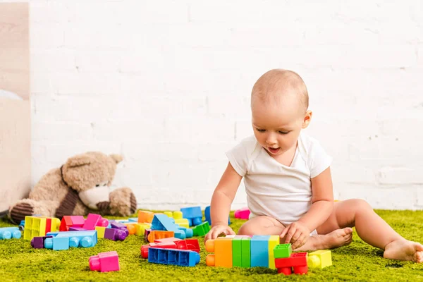 Χαριτωμένο Μικρό Παιδί Που Παίζει Πολύχρωμα Παιχνίδια Πράσινο Πάτωμα — Φωτογραφία Αρχείου