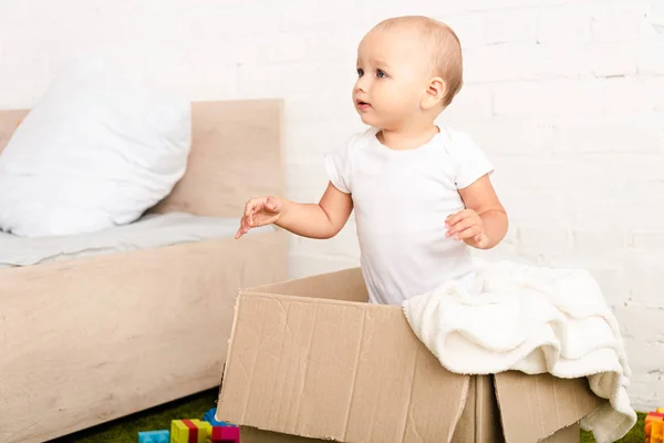 Little Child Standing Cardboard Box White Blanket Looking Away — Stock Photo, Image