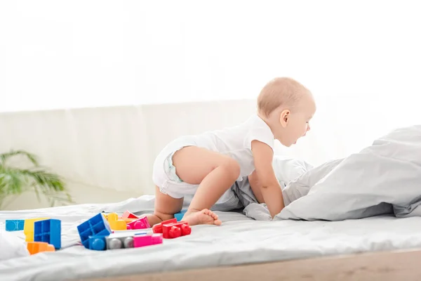 Lindo Descalzo Bebé Blanco Ropa Arrastrándose Cama Entre Juguetes —  Fotos de Stock