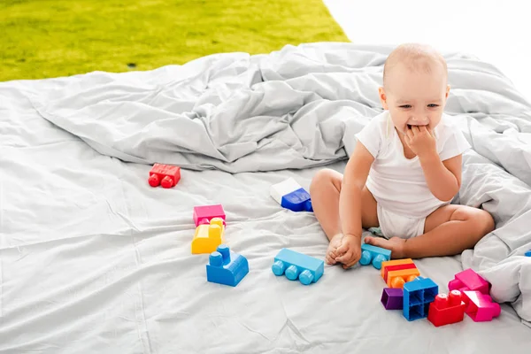 Funny Barefoot Baby White Clothes Sitting Bed Colorful Construction Taking — Stock Photo, Image