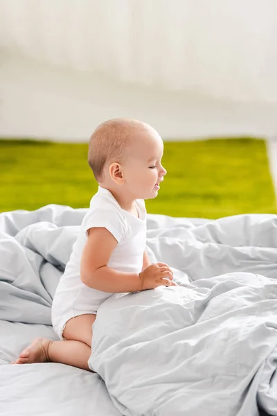 Side View Little Child White Clothes Sitting Bed Looking Forward — Stock Photo, Image