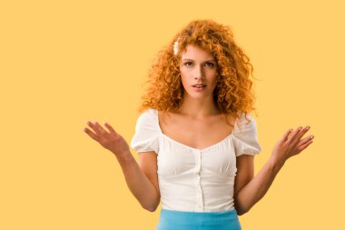 confused redhead woman with shrug gesture, isolated on yellow clipart