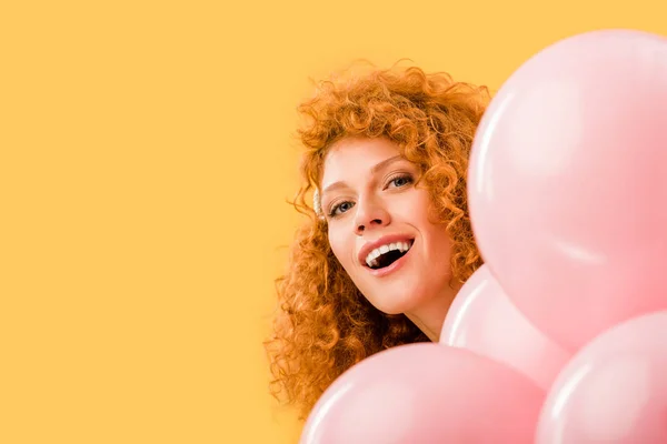 欢快的红发女人与粉红色的气球隔离在黄色 — 图库照片
