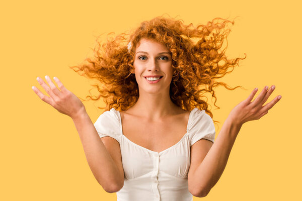 happy woman with curly red hair, isolated on yellow