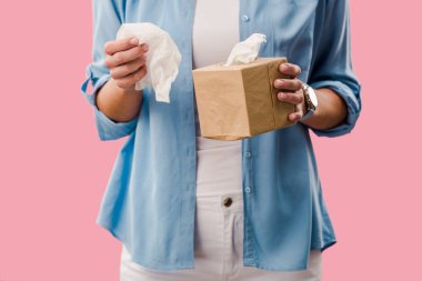 cropped view of woman with paper napkins, Isolated On pink clipart