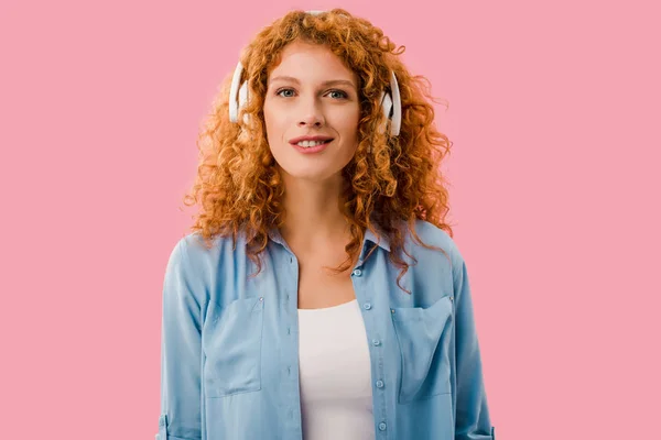 ヘッドフォンで音楽を聴く美しい赤毛の女性 ピンクで孤立 — ストック写真