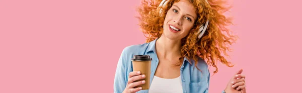红发女人与咖啡去跳舞和听音乐在耳机 孤立在粉红色 — 图库照片