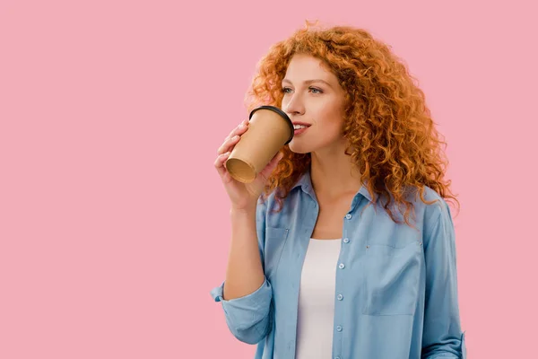 beautiful curly woman drinking coffee to go, Isolated On pink
