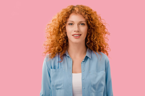 portrait of smiling attractive redhead woman isolated on pink
