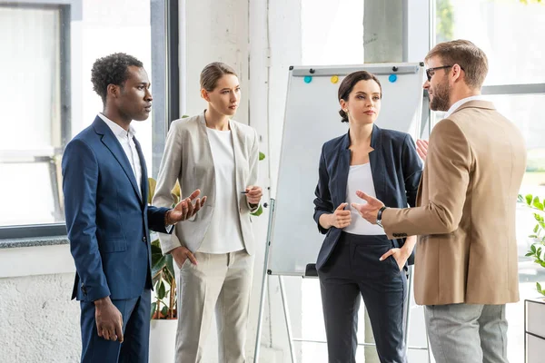 Vier Multiethnische Kollegen Formeller Kleidung Stehen Neben Flipchart Büro — Stockfoto