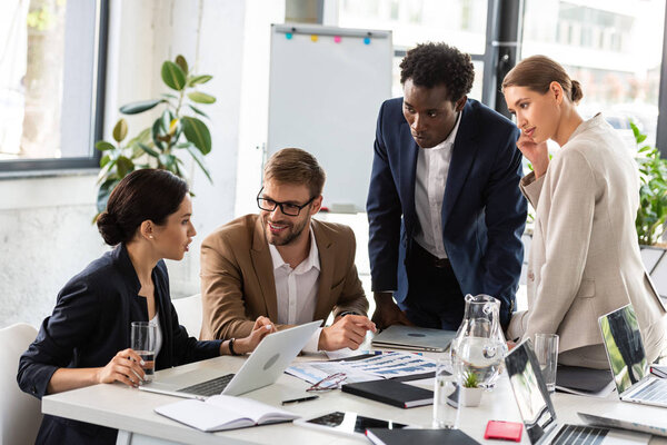 multiethnic businesspeople at table during conference in office